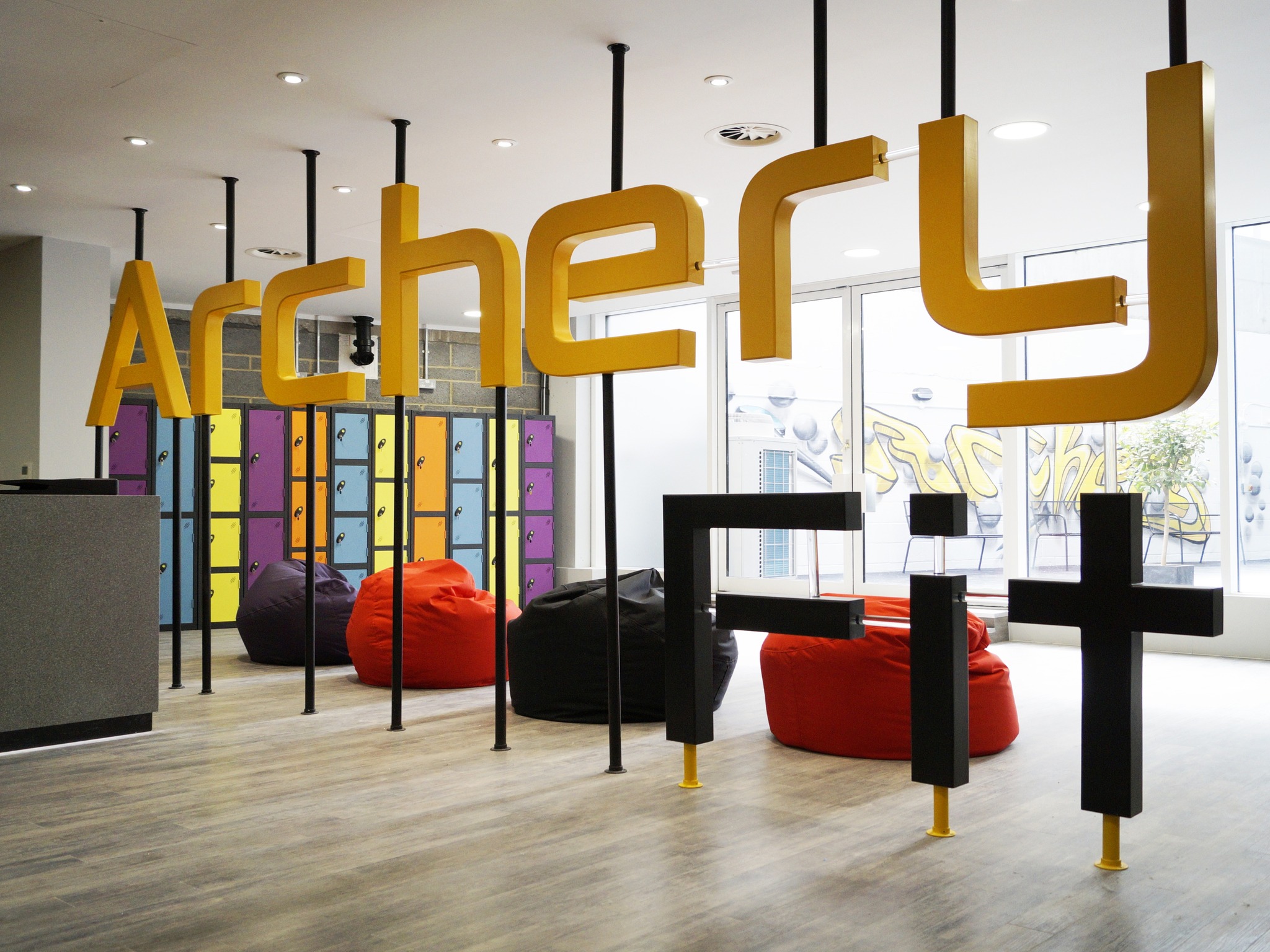 Archery Fit's Greenwich lobby — oversized gold Archery Fit signage and colourful locker bank